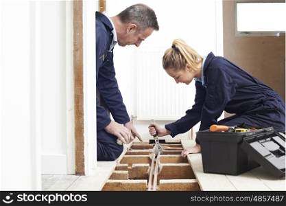 Plumber And Apprentice Fitting Central Heating