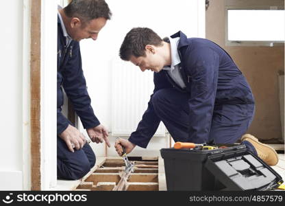 Plumber And Apprentice Fitting Central Heating in House