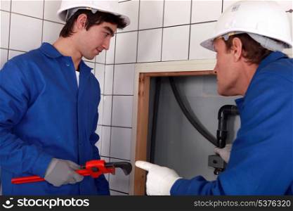 Plumber and his apprentice working together