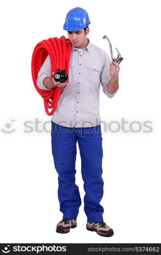 Plumber holding piggy-bank and tap