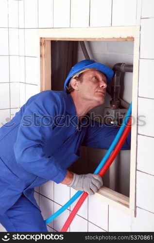 Plumber installing pipes