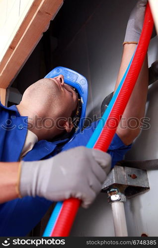 Plumber installing plastic domestic water pipes