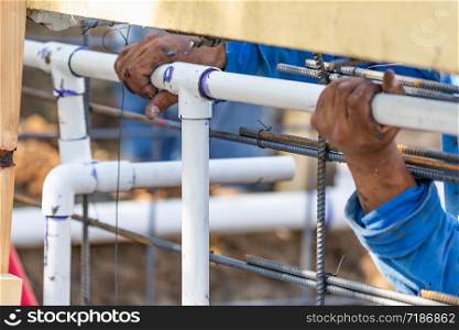 Plumber Installing PVC Pipe at Construction Site.