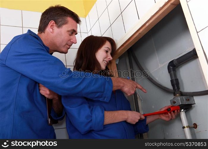 Plumber instructing his apprentice
