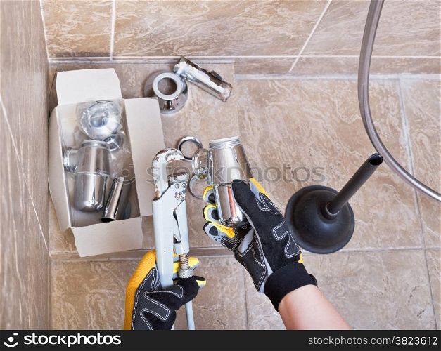 plumber repairs sink chrome plated trap in bathroom