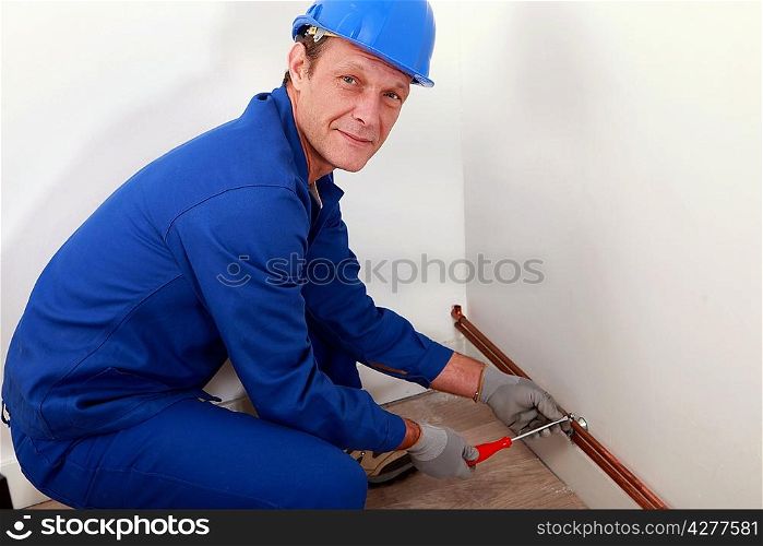 Plumber screwing copper water pipes in place
