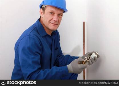plumber showing plumbing pieces