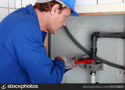 Plumber tightening a joint with a wrench