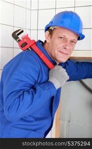 Plumber with a large red wrench held over his shoulder