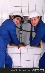 Plumber with young apprentice