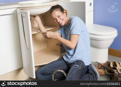 Plumber working on sink smiling