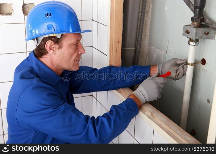 Plumber working on water pipes