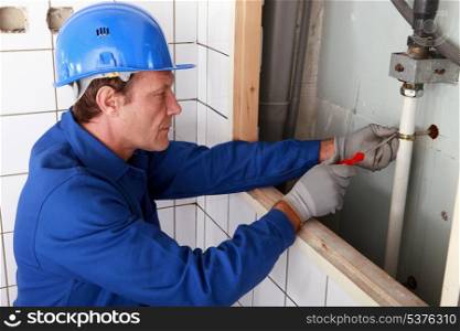 Plumber working on water pipes