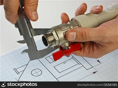 plumbing fittings in hand on the drawing
