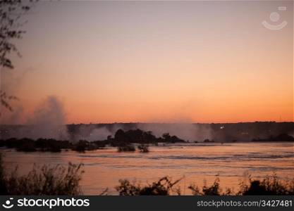 Plume of mist rising from Victoria Falls at sunset