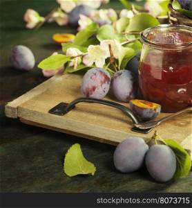 Plums and jar of jam on table. Homemade bio food concept