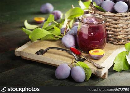 Plums and jar of jam on table. Homemade bio food concept