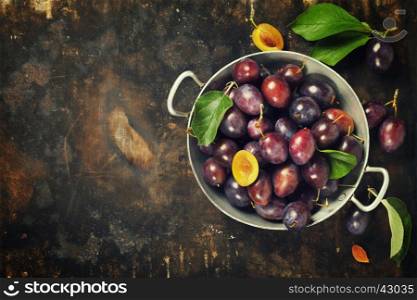 Plums in a bowl on a rural background. Fresh bio fruits