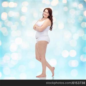 plus size and people concept - happy plus size woman in underwear background over blue holidays lights background. happy plus size woman in underwear