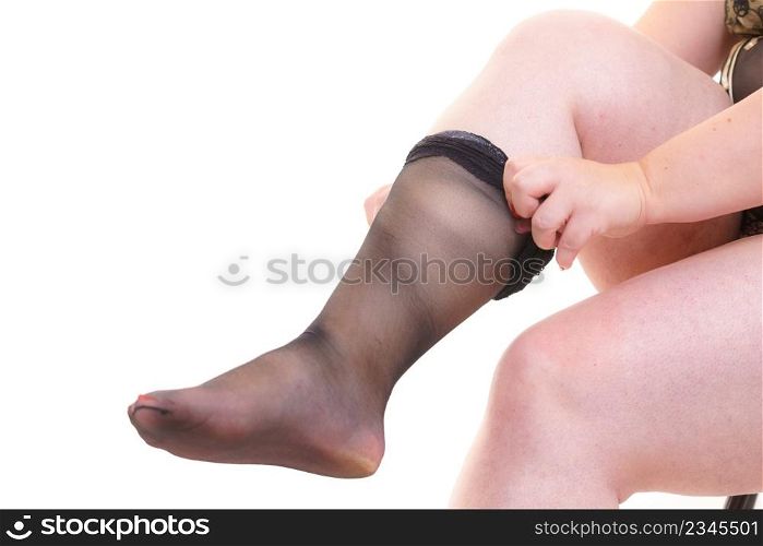 Plus size big chubby woman puts on black nylon stockings. Woman plus size puts on black nylon stockings