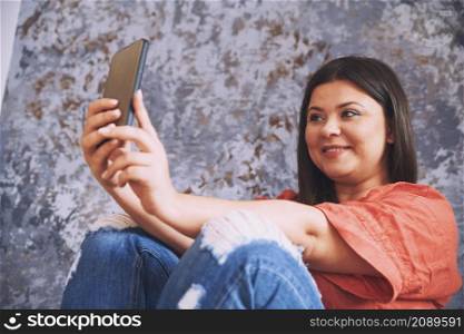 Plus size model making selfie via her smartphone