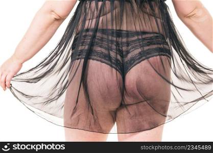 Plus size woman wearing black lace lingerie, thong panties and nightdress, back view. Big body, underwear concept.. Fat woman in lingerie back view.