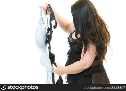 Plus size woman wearing lingerie holding bras, on white. Bosom, bra fitting, underwear and female dilemmas.. Woman plus size holding bras