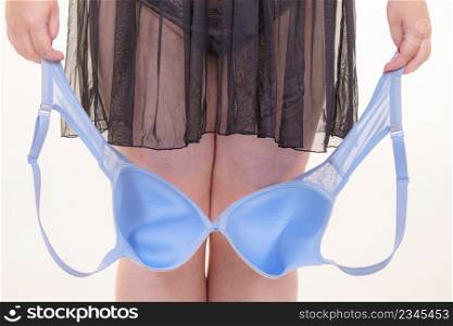 Plus size woman wearing lingerie holding ful cup bra, on white. Bosom, brafitting, underwear and female dilemmas.. Woman plus size holding bra