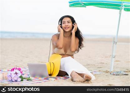 Plus size young woman sitting on tropical sand beach in summer. Holiday travel vacation.. Plus size young woman sitting on the beach.