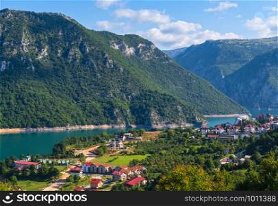 Pluzine town and famous Piva river canyon with its fantastic reservoir Piva Lake (Pivsko Jezero) and Pluzine town summer view in Montenegro. Nature travel background.