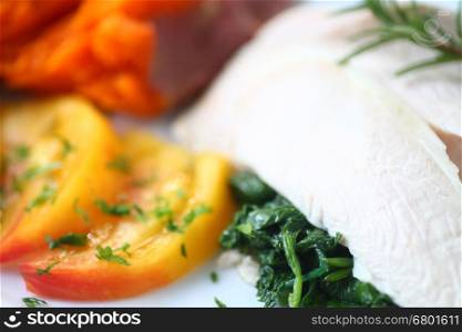 Poached chicken slices over sauteed baby kale with sweet potato and tomato