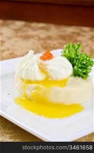 poached eggs in a nest of mashed potatoes with greens and caviar