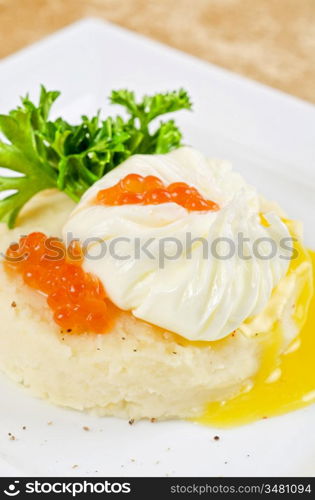 poached eggs in a nest of mashed potatoes with greens and caviar