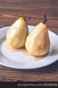 Poached pears in white wine on the white plate