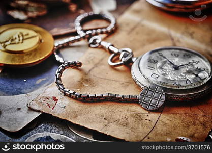 pocket clock with chain on background of old photos