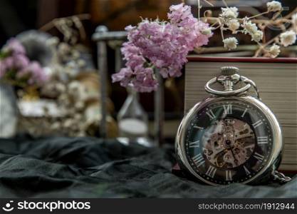 Pocket watch, blur stack of old book, hourglass, vintage binocular and world desk globe on dark background. Journey and Learning Concept, Vintage Style.
