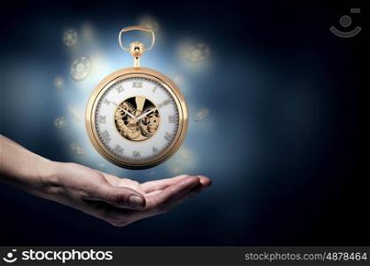 Pocket watch. Close up image of human hand holding pocket watch