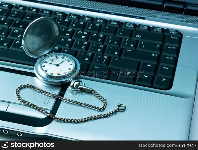 pocket watch on a laptop keyboard
