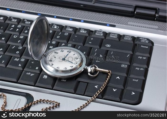 pocket watch on a laptop keyboard