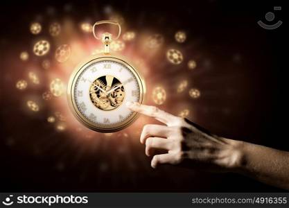 Pocket watch sign. Close up image of human hand touching pocket watch