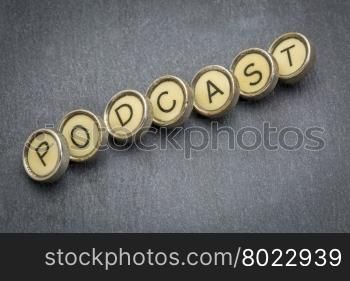 podcast word in old round typewriter keys against gray slate stone