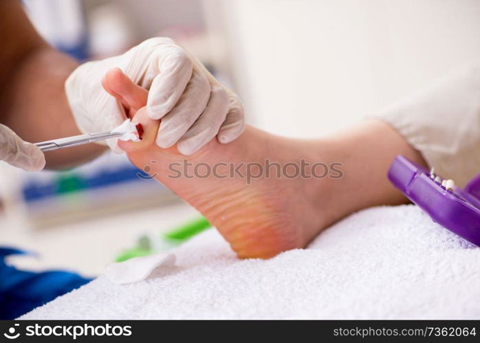 Podiatrist treating feet during procedure