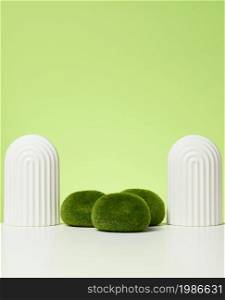podium with moss and arches to showcase cosmetics, products and other goods. Green background