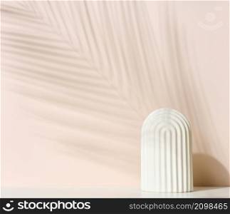 podium with white arche to showcase cosmetics, products and other merchandise. Shadow palm leaf