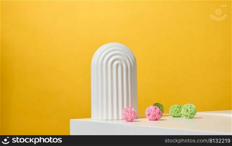 podium with white arches to showcase cosmetics, products and other goods, yellow background
