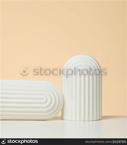 podium with white arches to showcase cosmetics, products and other merchandise. beige background
