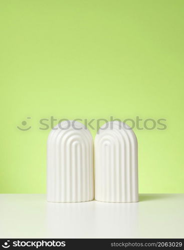 podium with white arches to showcase cosmetics, products and other merchandise. Green background