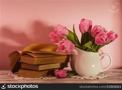 Poem still life with books and pink tulips