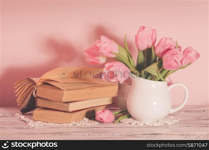 Poem still life with books and pink tulips. Poem still life