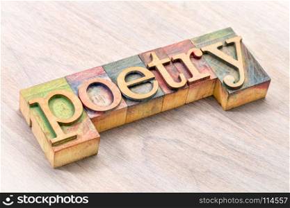 poetry word abstract- text in vintage letterpress wood type blocks against grained wood